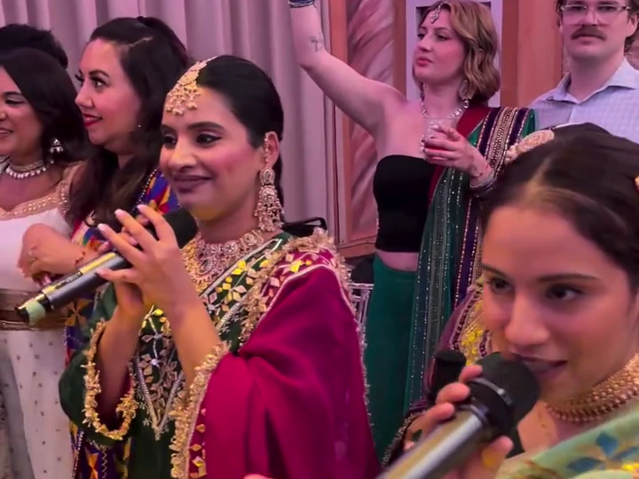 Surleena and fellow singers smiling as they perform among guests at a Jaago celebration